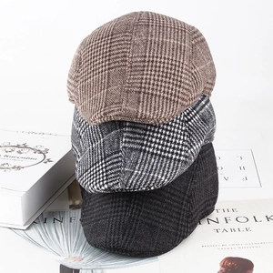 Detailed texture of three vintage checkered tweed newsboy caps in various colors