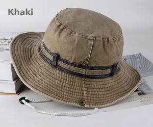 Dettaglio cappello da pescatore kaki con cordino antivento su sfondo minimalista