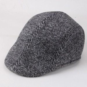 Detail of grey herringbone flat cap showing thick textured fabric for autumn and winter