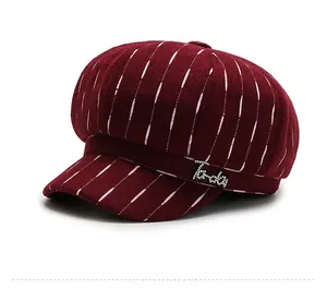 Close-up of wine red baker boy hat with pink pinstripes and rhinestone logo detail