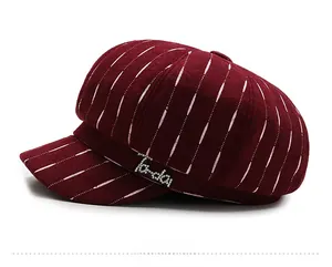 Side view of wine red newsboy cap featuring white pinstripes and Ta-da rhinestone lettering
