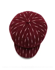 Top view of a burgundy newsboy cap with white vertical stripes and wool-like texture