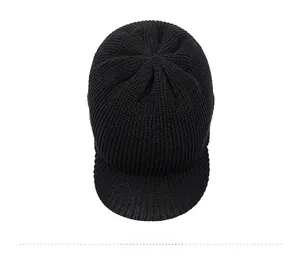 Top view of a black knitted winter hat with visor featuring vertical ribbed texture