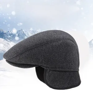 Detail view of winter flat cap with ear flaps and thick warm lining in dark grey