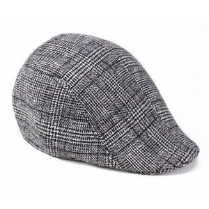 Close-up of houndstooth plaid wool fabric texture on a vintage autumn flat cap