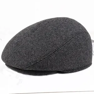 Detail of grey twilled newsboy cap for men showing textured fabric and curved side profile