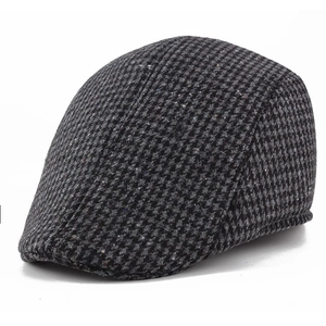 Detail shot of the classic houndstooth pattern and tweed texture on this men's flat cap