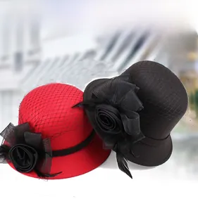 Detailed view of wool felt pillbox hats with mesh veil and floral feather embellishments
