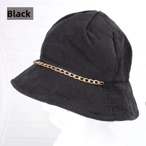 Dettaglio di cappello a secchiello in velluto nero con catena d'oro alla moda