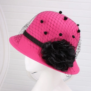 Detail of rose red wool felt hat featuring black lace veil and silk flower decoration