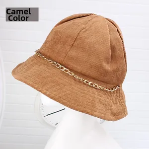 Dettaglio cappello bucket in velluto a coste cammello con cuciture e catena dorata