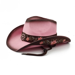 Detail of pink straw cowboy hat with floral embroidery and adjustable brown chin strap