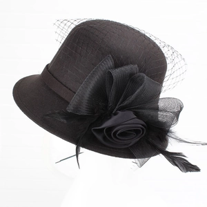 Detail of vintage wool felt cloche hat with black mesh veil, satin roses and feathers