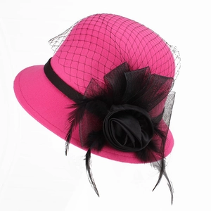 Detail of fuchsia wool hat with black mesh veil, satin rose flower and feathers