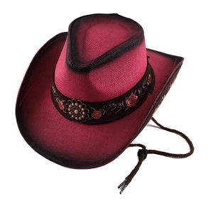 Close-up of pink straw cowboy hat featuring floral embroidery and vintage metal ornament