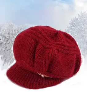 Detail of burgundy knitted winter hat with visor and rhinestone metal buckle ornament