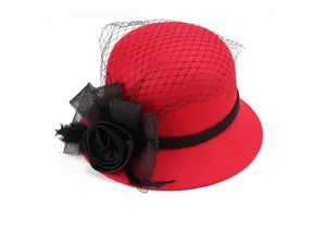 Detail of red wool felt hat featuring a black satin rose, feathers, and a vintage mesh veil