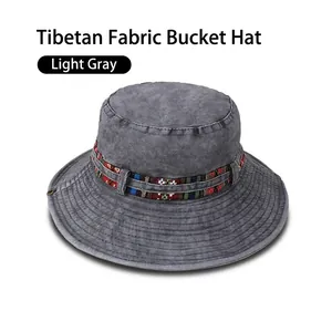 Detail view of light gray bucket hat with colorful ethnic pattern woven ribbon trim