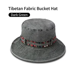 Detail of dark green washed canvas outdoor sun hat with ethnic style woven band decoration