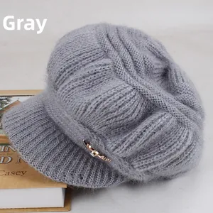 Detail view of grey knit baker boy hat showing plush texture and gold bow ornament