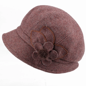 Detail view of the floral embroidery and brown fur ball on the warm wool winter hat