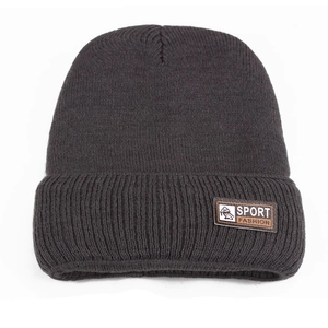 Close-up of thick charcoal grey knit beanie with sport fashion leather patch detail