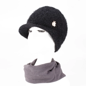 Detail of black winter knit hat with plush visor and matching neck warmer on model
