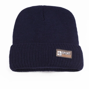 Detail of navy blue ribbed knit beanie with brown leather logo patch and sport pattern