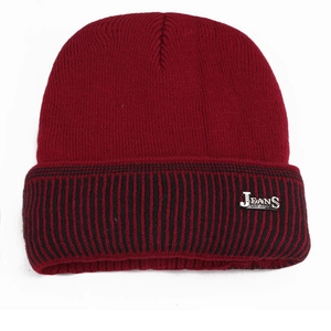 Close-up of burgundy knit beanie featuring a striped cuff and a silver JEANS metal tag