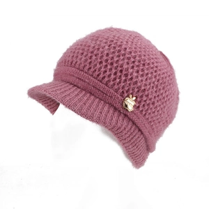 Detail of dusty pink knit visor hat with honeycomb mesh pattern and gold apple badge