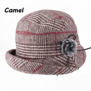 Detailansicht des karierten Winterhuts in Camel mit rotem Streifen und Pelz-Bommel