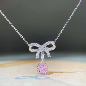 Vista macro dettagliata della collana in argento S925 con gemma rosa e ciondolo a fiocco