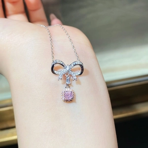 Dettaglio della collana con fiocco in argento e pietra rosa taglio cushion