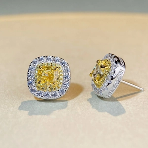 Gros plan de boucles d'oreilles en argent avec pierres jaunes taille coussin et double halo