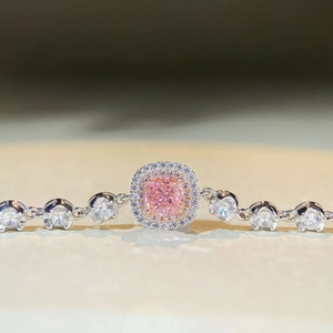 Macro shot of silver bracelet with pink cushion-cut gem and double halo setting