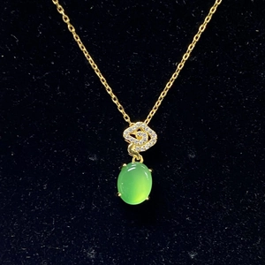 Detail of green oval agate pendant with S-shaped gold inlaid zircons on fine chain