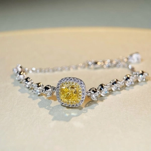 Gros plan d'un bracelet en argent avec pierre jaune taille coussin et pavé de diamants