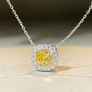 Vue macro d'un pendentif avec pierre jaune taille coussin et double halo de diamants