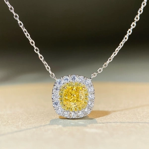Vue macro d'un pendentif en argent avec pierre jaune taille coussin et double halo serti