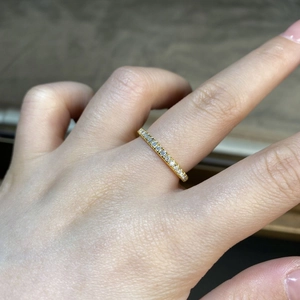 Detail showing 18K gold plated S925 silver ring with pave-set moissanite stones on finger