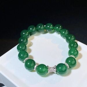 Détail macro du bracelet en perles d'agate vert foncé avec nœud en argent et diamants