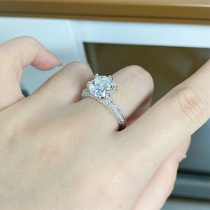 Close-up of a 925 silver moissanite ring with six-prong setting on a finger