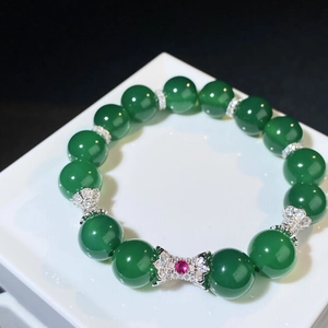 Détail du bracelet en perles de calcédoine verte avec nœud en diamant argenté et gemme rouge