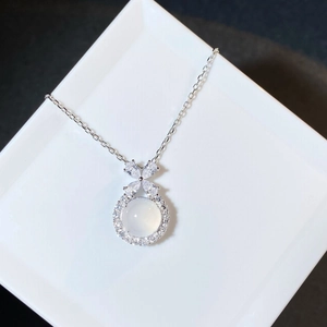 Close-up of S925 silver bow pendant with white chalcedony and inlaid zircon accents