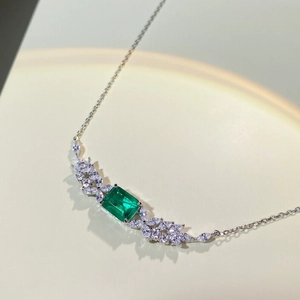 Macro shot of emerald-cut green gemstone pendant with marquise-cut side stones