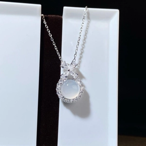 Detail of S925 silver pendant with white chalcedony and bow knot diamond halo design