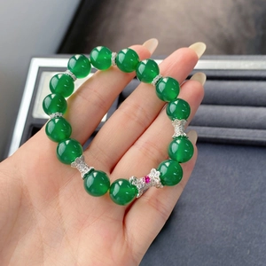 Gros plan du bracelet en argent S925 avec perles de calcédoine verte et breloque papillon