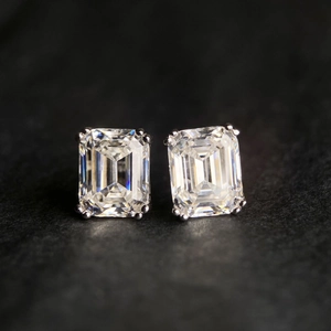 Détail macro de boucles d'oreilles moissanite taille émeraude sur monture à quatre griffes