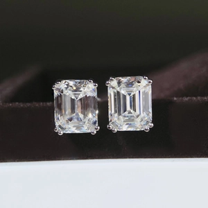 Gros plan de boucles d'oreilles moissanite taille émeraude sur argent poli