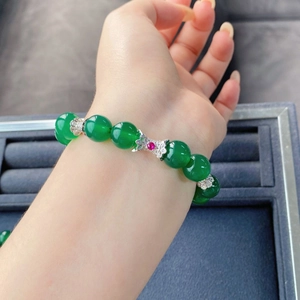 Détail du bracelet en calcédoine verte avec des séparateurs floraux en argent et pierre rouge